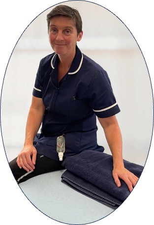 Image of Evonne Foulkes, massage therapist Evonne Foulkes, mobile injury treatments specialist, sits on a treatment couch with a hand on a folded towel, dressed in a tnavy herapist tabard.